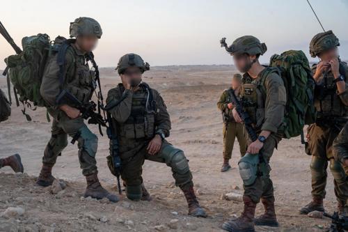 צוות של לוחמים במדבר מדברים בכריעת ברך