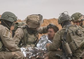 לוחמים לוחמי יחידה 669 מטפלים מעניקים טיפול רפואי בפצוע פצוע מכוסה שמיכה רפואית כסופה שמיכת כסף פצועים בשטח רצועת עזה בעזה