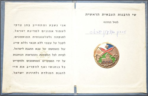 טירון ג'דעאן (גדעון) עבאס (לימים אל"ם) נשבע אמונים לצה"ל. מימין מדליון ובו בחלקו העליון מגן דוד על רקע כחול ולבן, מתחתיו סמל החרבות המוצלבות של יחידת המיעוטים, מתחתיו תבליט של נבי שועייב ומתחתיו המילים קבר יתרו בעברית ונבי שועייב בערבית (באדיבות אל"ם [במיל'] ג'דעאן עבאס)